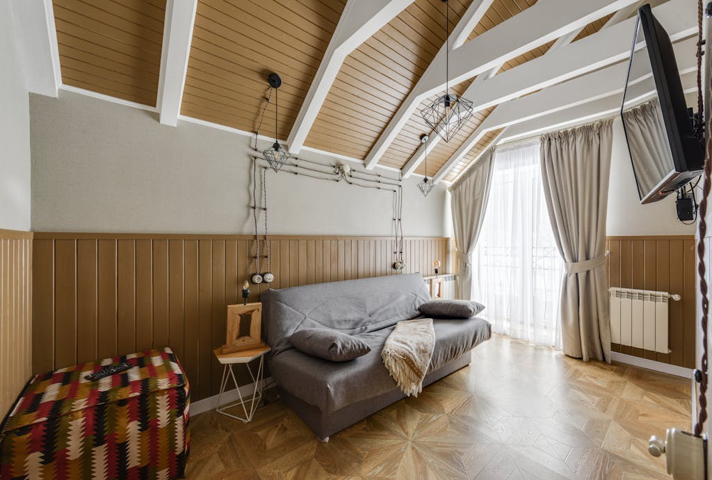 Bright and cozy living room featuring a sofa bed and TV, perfect for relaxation.