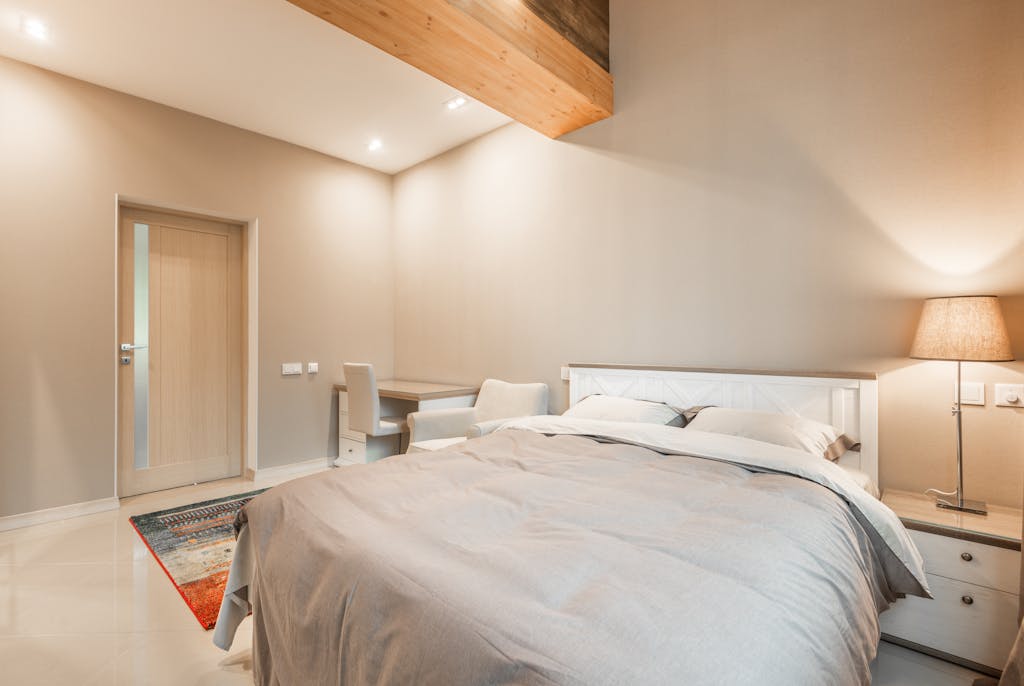 Sleeping Nook: 6 Sentuhan untuk Kenyamanan Maksimal di Kamarmu 4 Bright and cozy modern bedroom with minimalist decor and comfortable furnishings.