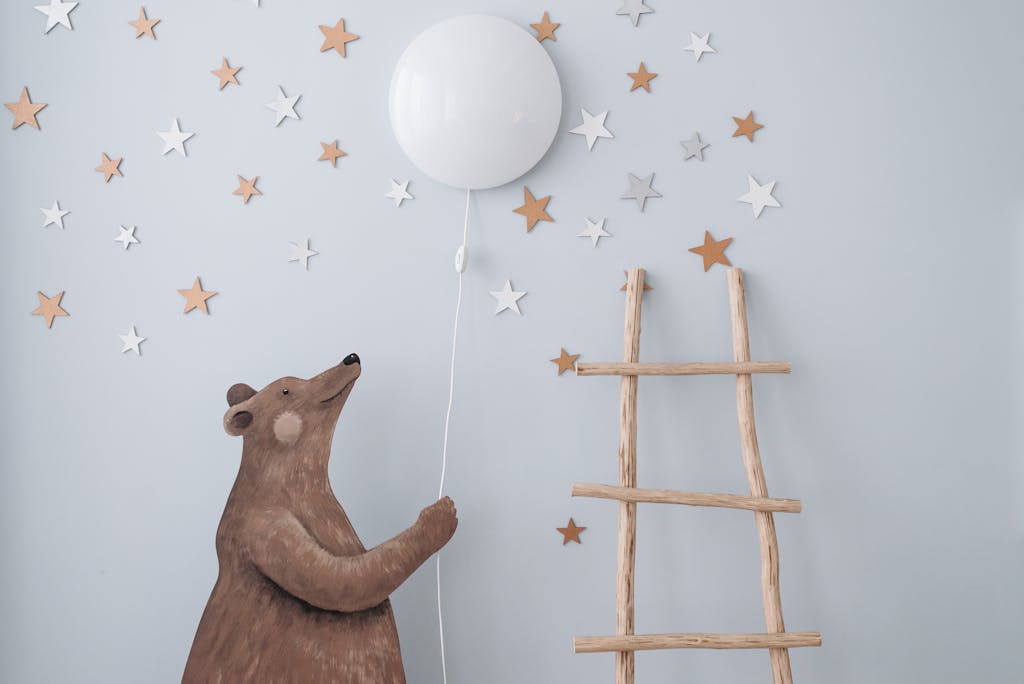 6 Wallpaper Ketinggalan Zaman dan Alternatif Penggantinya 7 Charming nursery decor featuring a bear with a balloon, stars, and a wooden ladder for playful ambiance.