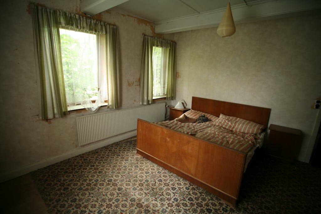 Cat vs Wallpaper, Mana yang Lebih Hemat? Analisis Desain, Biaya, dan Ketahanan 4 Charming rustic bedroom featuring wooden furniture and natural light from windows.
