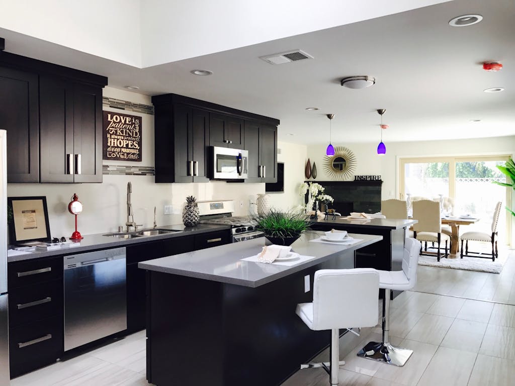 Investasi Interior: Ini Bagian Rumah yang Layak Dibayar Mahal 4 Sleek open-plan kitchen with modern decor, featuring stainless appliances and bar seating.