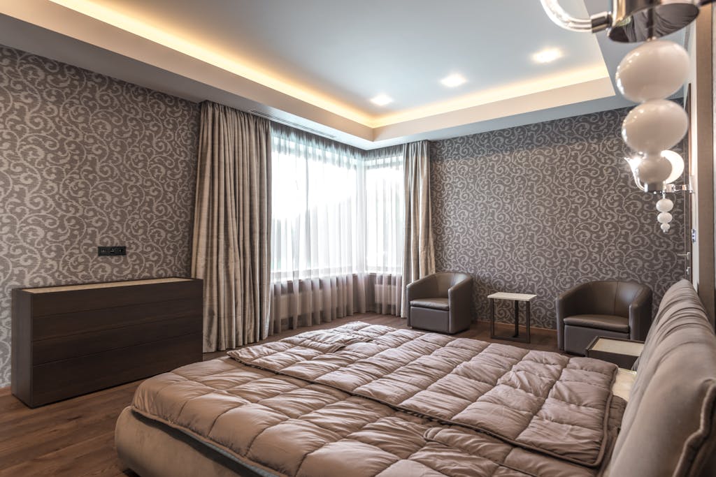 Cat vs Wallpaper, Mana yang Lebih Hemat? Analisis Desain, Biaya, dan Ketahanan 5 Spacious modern bedroom featuring elegant decor and luxurious furnishings.