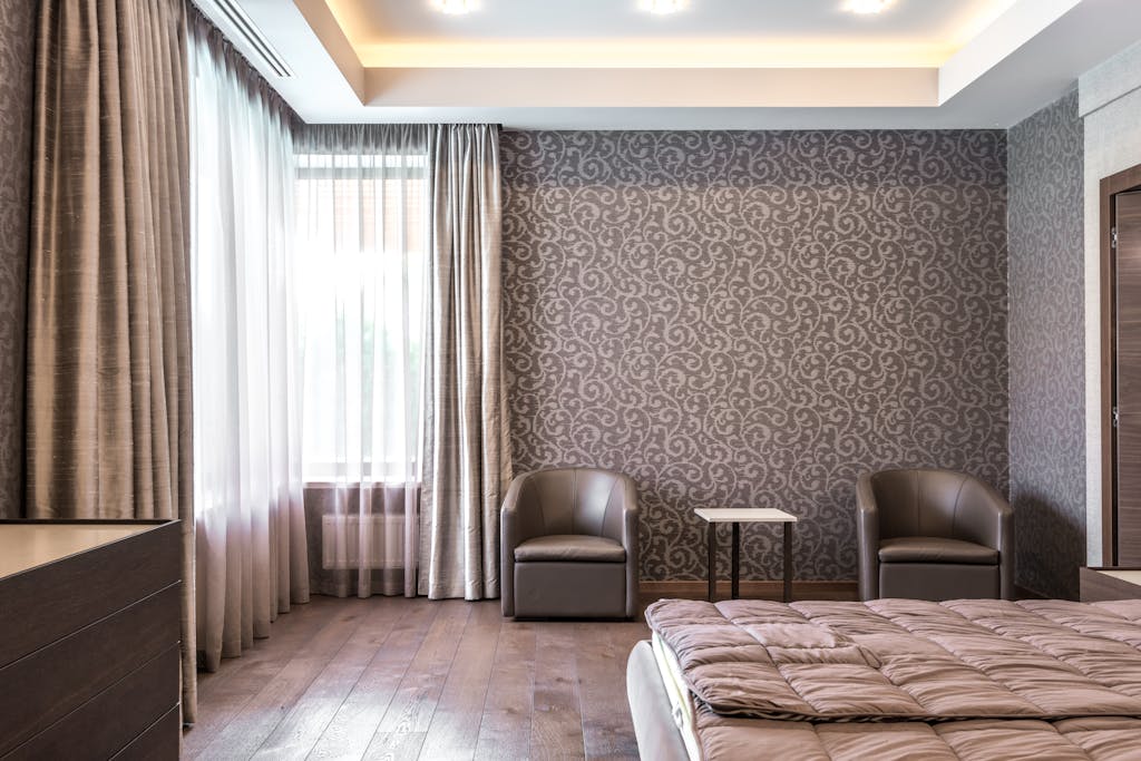 7 Cara Merawat Wallpaper Dinding agar Awet dan Warnanya Tetap Cerah 7 Spacious modern bedroom with stylish wallpaper and elegant furnishings.