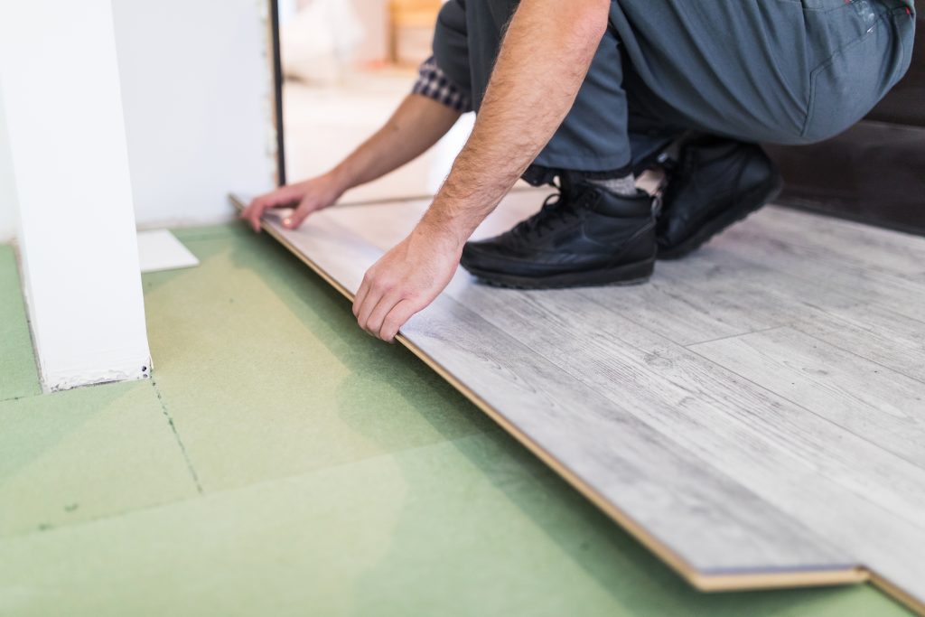worker processing floor with laminated flooring boards