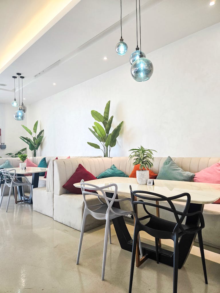 Bright and modern café interior in Dubai with colorful cushions and greenery.