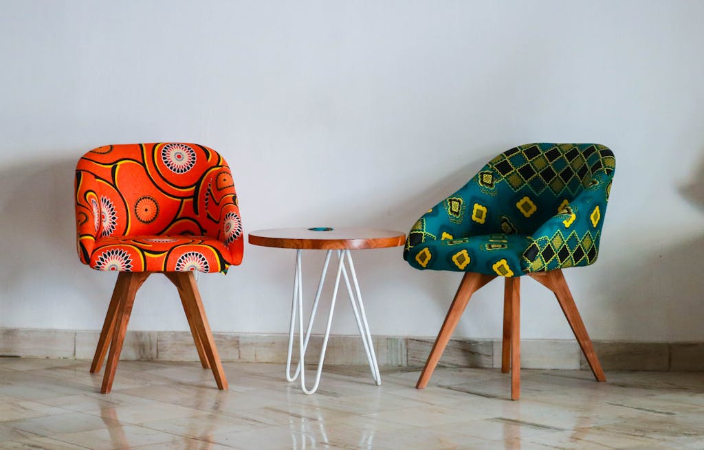 Furnitur Custom atau Ready Stock? Panduan Menentukan Pilihan Terbaik untuk Hunian 4 Brightly colored modern chairs and table in a minimalist room for vibrant decor ideas.