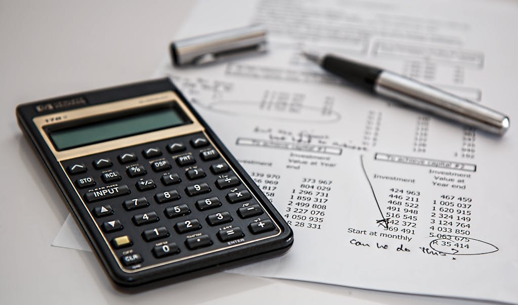 Panduan Lengkap Renovasi Kamar Tidur: Dari Perencanaan sampai Estimasi Biaya 4 Close-up of financial documents with calculator and pen, ideal for business management themes.