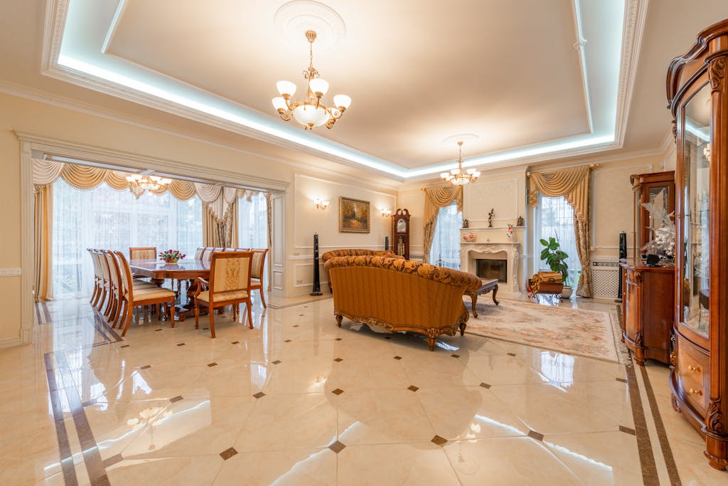 6 Pilihan Flooring Rumah yang Membuat Ruangan Terlihat Mewah 3 Spacious and elegant interior design featuring a luxe living room and dining area.