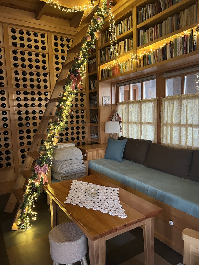 Warm, inviting cabin interior adorned with festive lights and decorations, perfect for a cozy holiday setting.